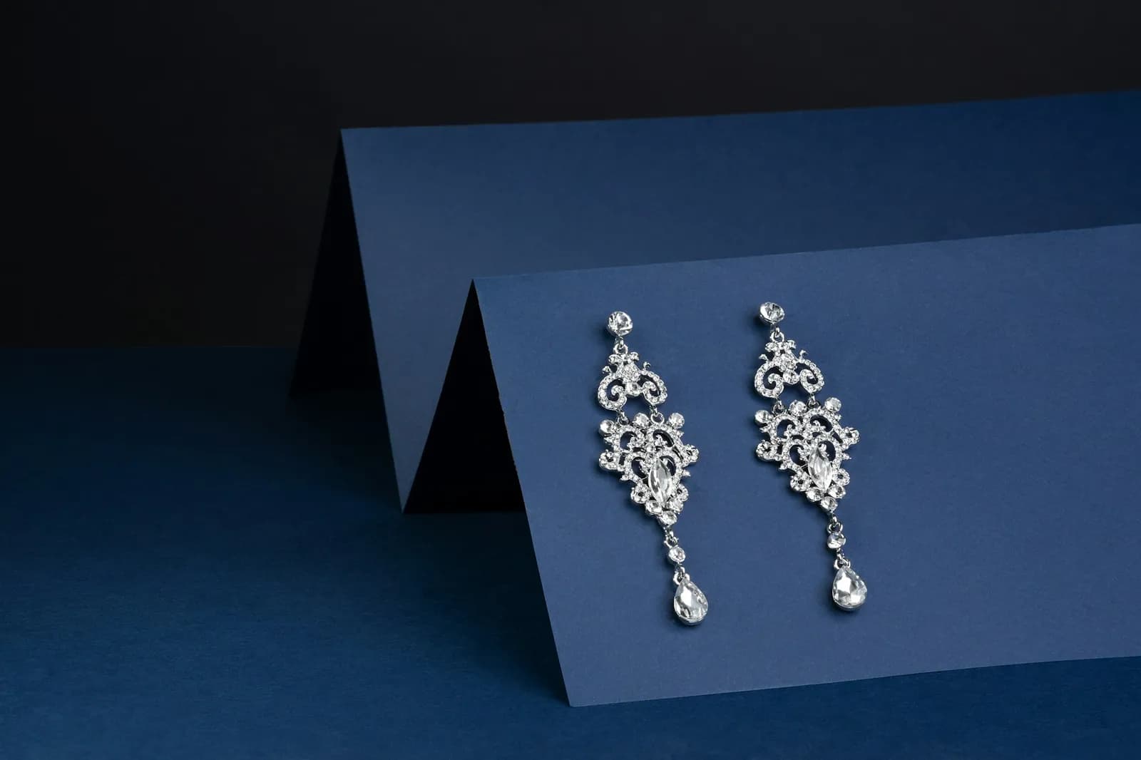 A pair of crystal drop earrings on navy card
